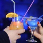 Hands make a toast with colorful cocktail drinks