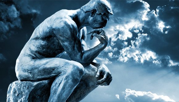 Stone statue of The Thinker with clouds in background