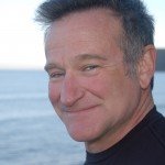 Closeup of Robin Williams smiling with beach in background