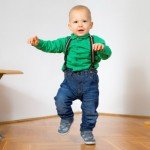 Toddler wearing suspenders learning to walk