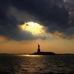The Statue of Liberty in the distance with clouds surrounding