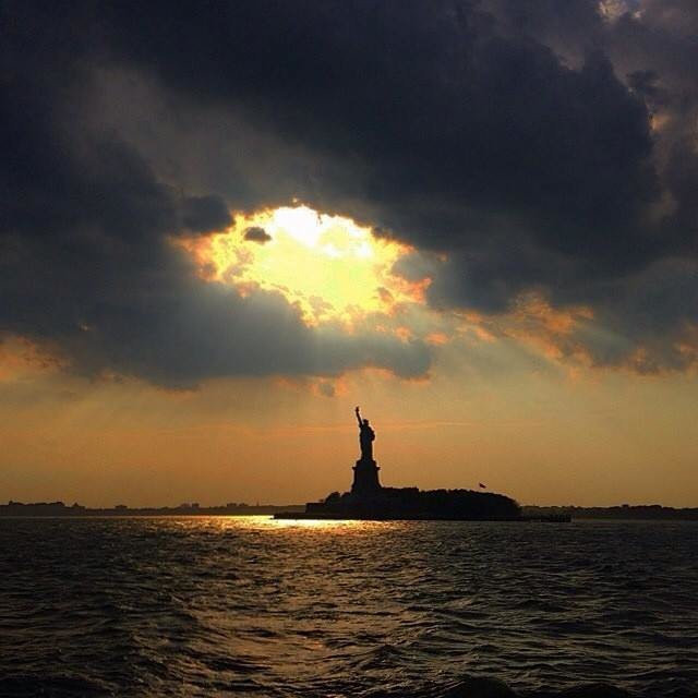 The Statue of Liberty in the distance with clouds surrounding