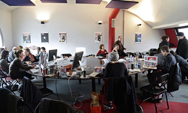 People gathered around glass tables with computers