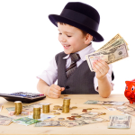 Kid playing at table with varying types of money and a calculator