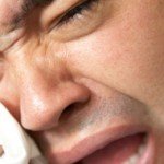 Man cries dramatically while holding tissue to eye