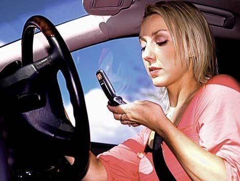 Woman stares at cellphone while she's driving