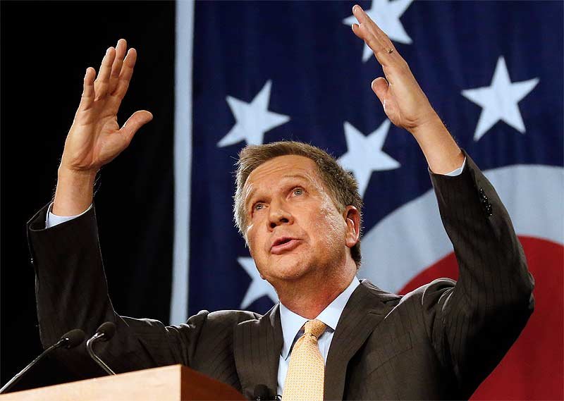 John Kasich holds hands up during speech