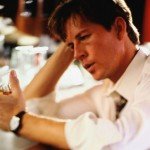 Man holds glass of alcohol sitting at the bar