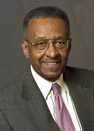 Portrait of Walter E. Williams in grey suit and purple tie