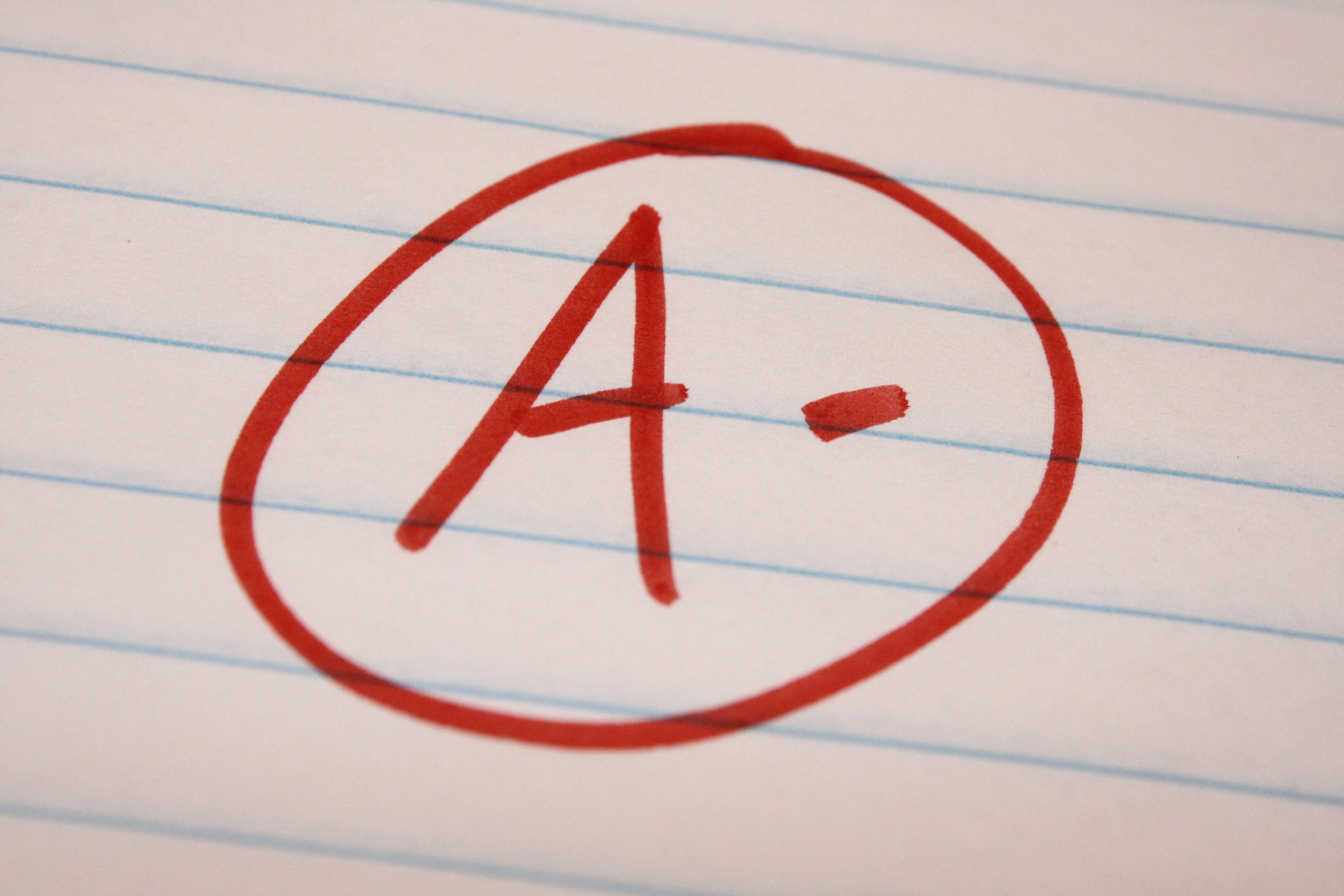 A- is written and circled in red on lined notebook paper