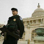 Homeland Security officer stands guard with rifle