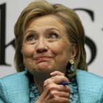 Hillary Clinton smiling and holding blue pen at book signing