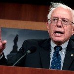 Bernie Sanders holds hand up during speech