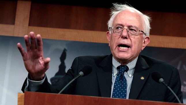 Bernie Sanders holds hand up during speech