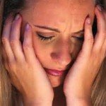 Woman holds face in emotional distress