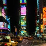 Night-time view of NY's Times Square with the city lights and taxis