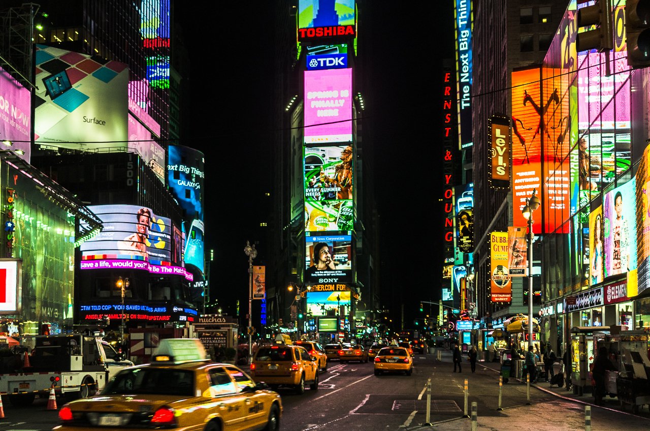 Night-time view of NY's Times Square with the city lights and taxis