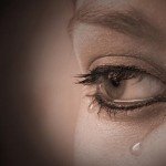 Closeup of woman's eye with teardrops forming