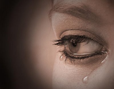 Closeup of woman's eye with teardrops forming