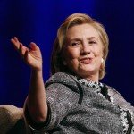 Hillary Clinton smiling with hands up during speech