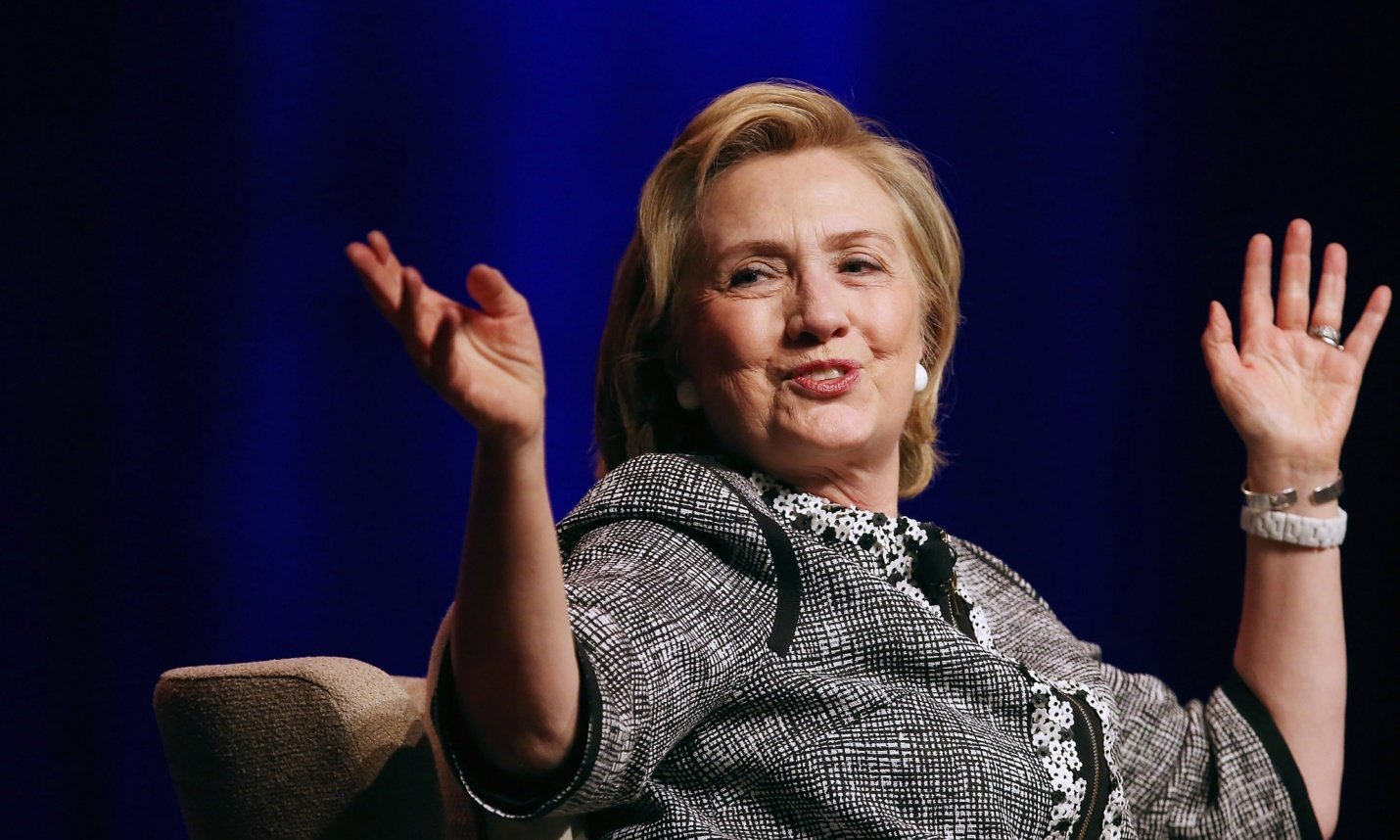 Hillary Clinton smiling with hands up during speech