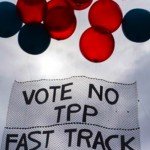 Red and black balloons on sign that reads Vote No TPP Fast Track