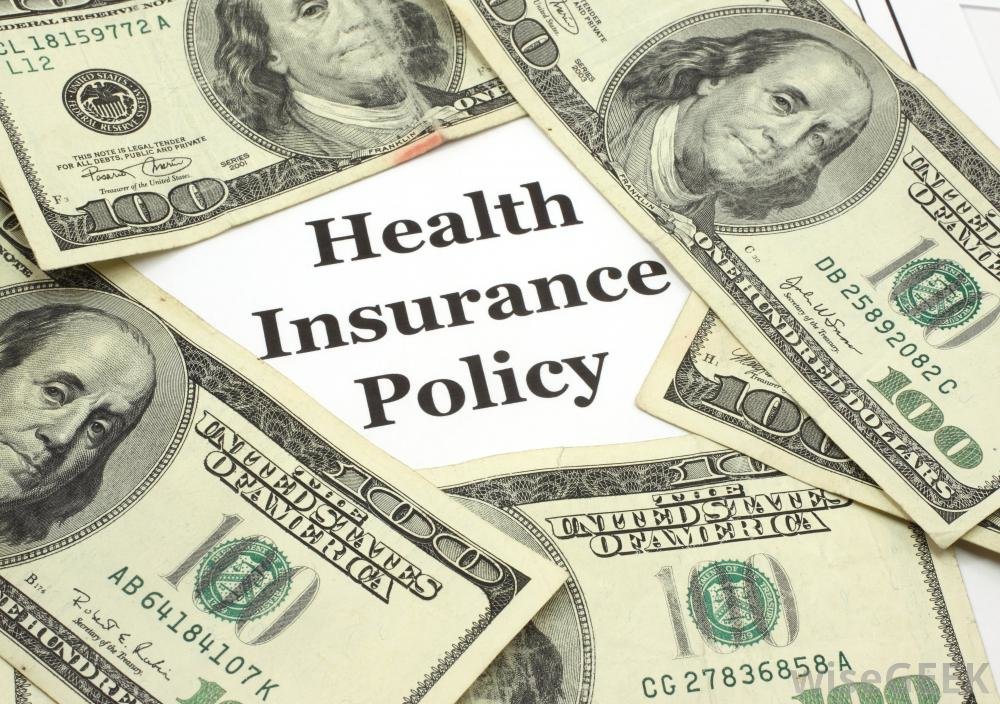 The words Health Insurance Policy surrounded by multiple 100-dollar bills