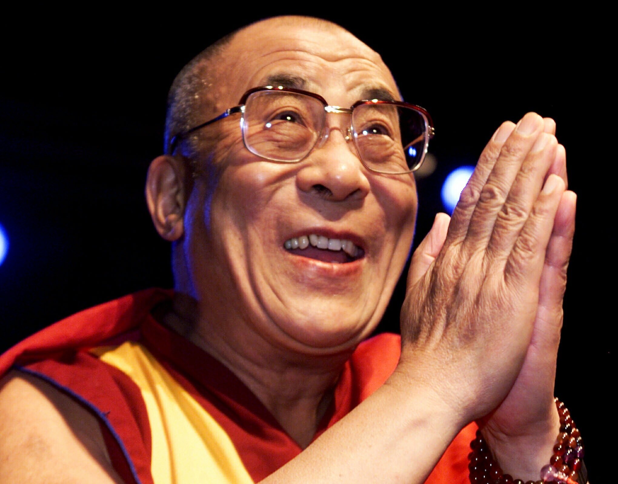 Closeup of the Dalai Lama as he smiles and greets