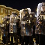 Police lined up on streets protected with shields