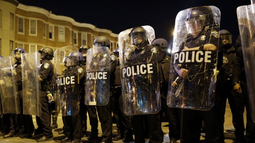 Police lined up on streets protected with shields