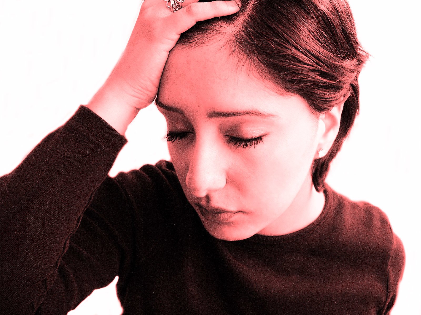 Closeup of woman with eyes closed holding hand to head
