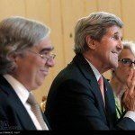 John Kerry smiles and claps at a conference