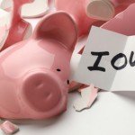 Smashed pink piggy bank with note that reads IOU