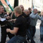 Men hold back another man during a riot movement