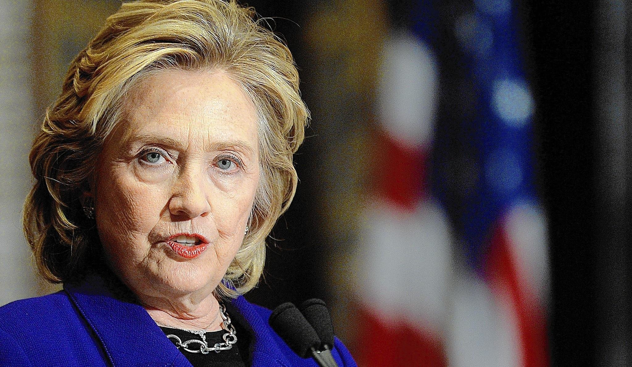 Hillary Clinton gives speech with American flag in background