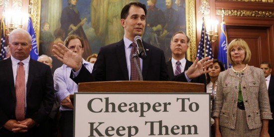 Scott Walker gives speech as people stand behind him