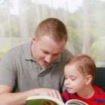 A man reads to young child