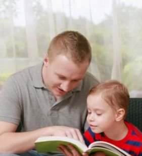 A man reads to young child