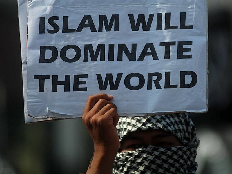 Woman holds sign reading Islam will dominate the world