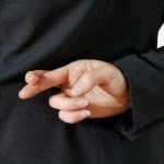Woman holds hand behind back with fingers crossed