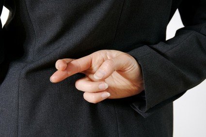 Woman holds hand behind back with fingers crossed