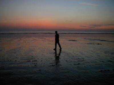 Person walking on the beach during a sunset