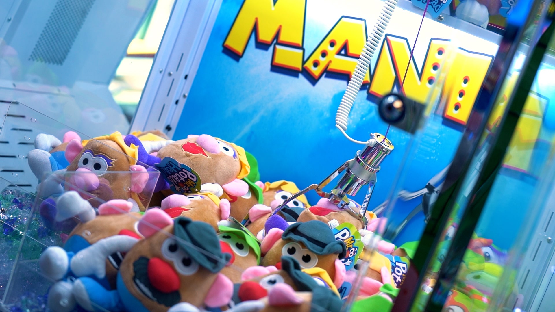 A Mr. Potato Head claw machine game at an arcade.
