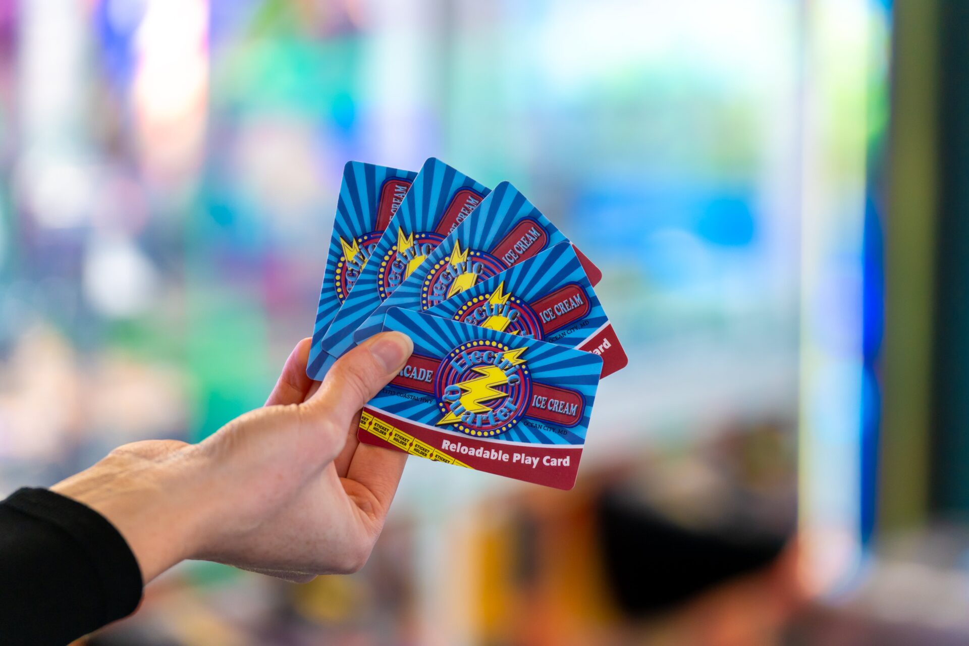 A person holding reloadable game cards at an arcade