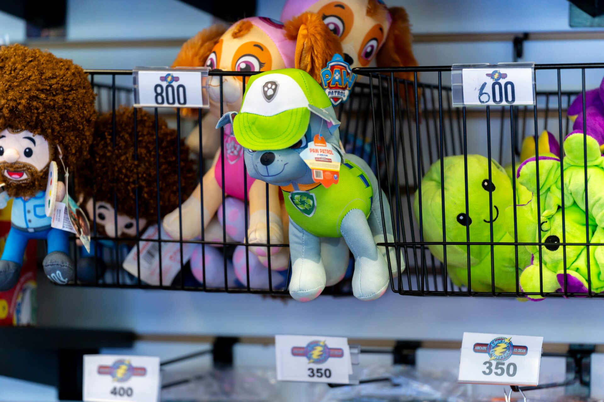 Stuffed animals on a prize shelf at an arcade.