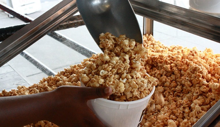 scooping kettle corn into plastic tub