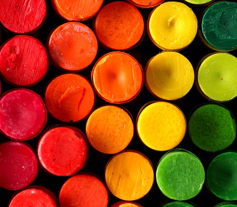 top down closeup view of crayons as circles in rainbow spectrum