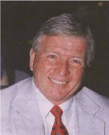 a man in a suit and tie smiling for a picture