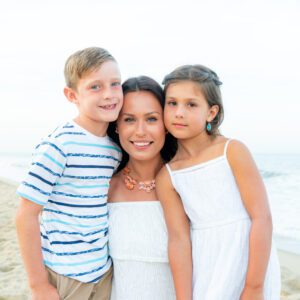 three children are posing for a photo on the beach