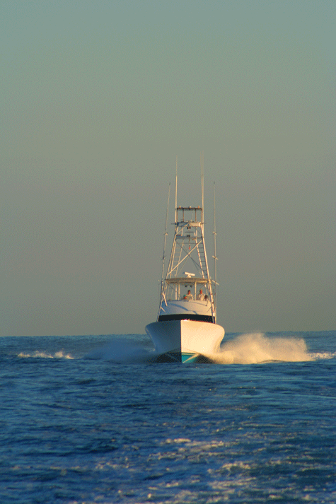 Fishing boat sailing forward under a grey/green sky in Ocean City MD